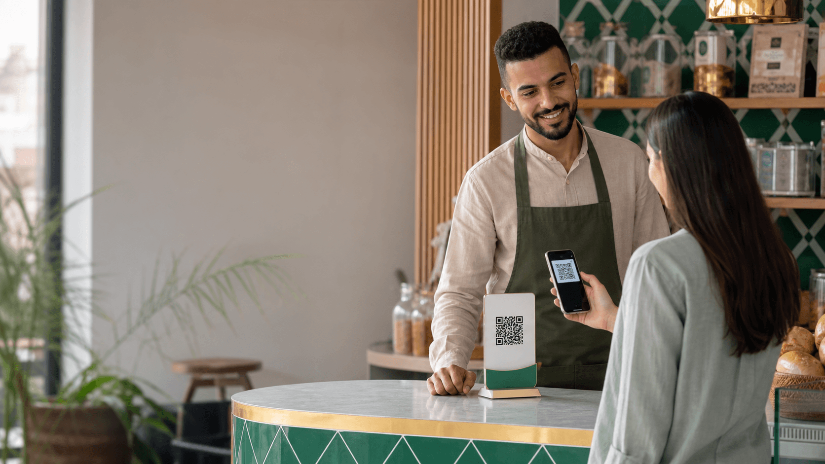 تاجر يستقبل دفعة عبر رمز QR في مقهى